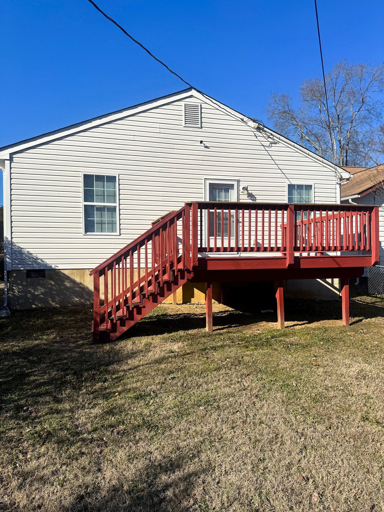 A white single‑story house with a red raised deck and stairs on the back side  belonging to Sponsored Residential Providers Xaiver Heath and David Williams in Richmond, Virginia.
