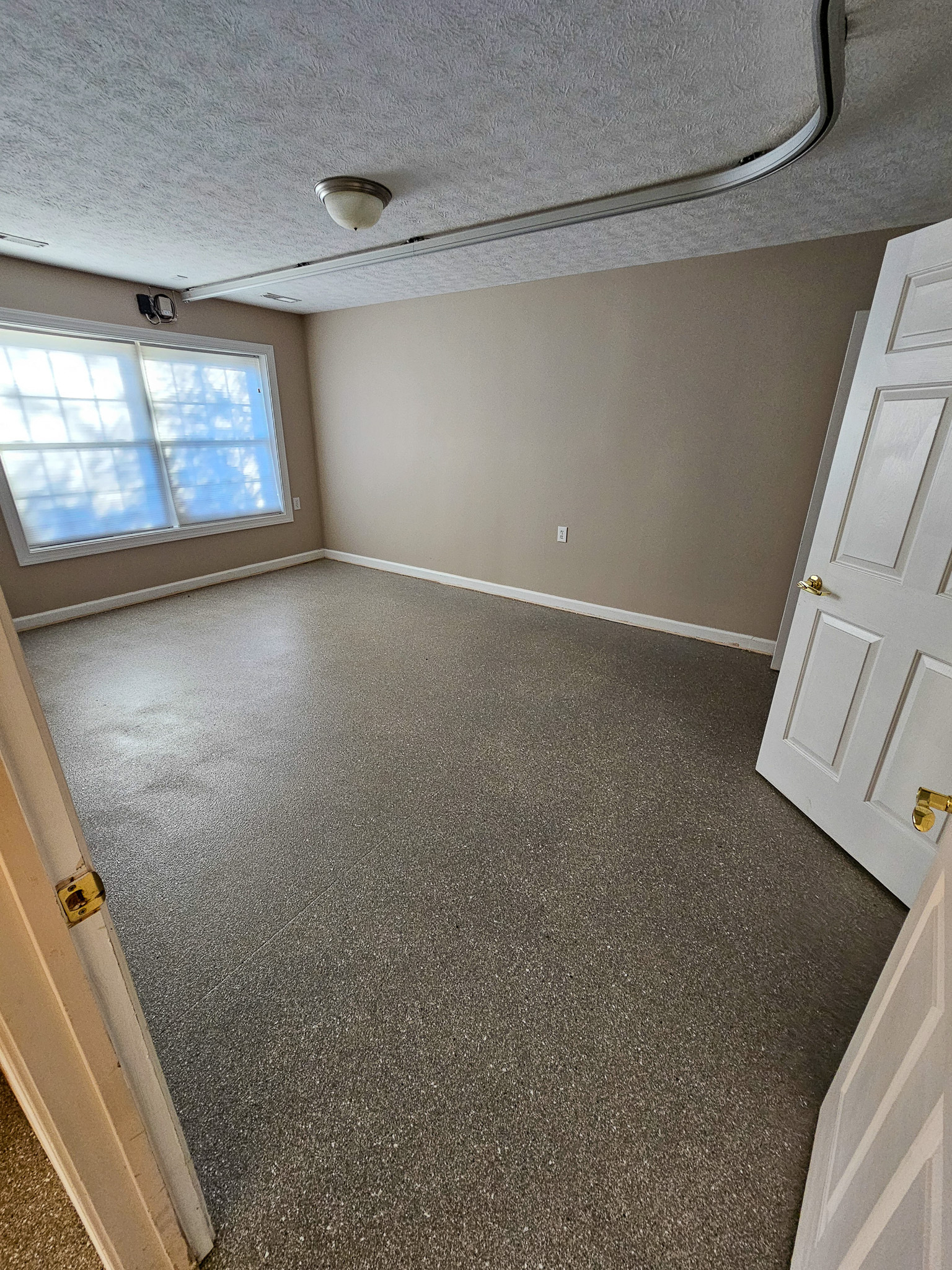 An empty room with beige walls and a large window is seen from the doorway at Boonsboro Group Home in Lynchburg, Virginia.