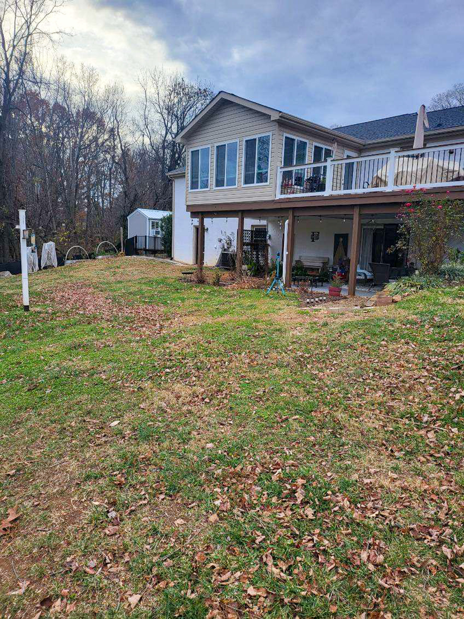 A house with an elevated porch and wooden posts faces a sloping yard with scattered leaves at the home of Sponsored Residential Providers Scott and Tedra Flanders in Lynchburg, Virginia.
