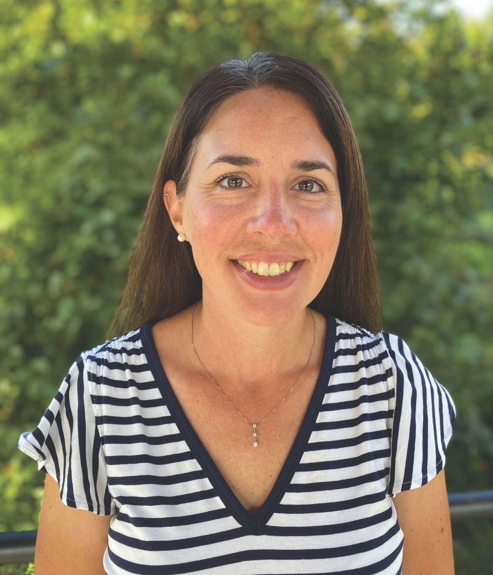 Assistant Director of Admissions Lisa Schalasny smiling in front of greenery