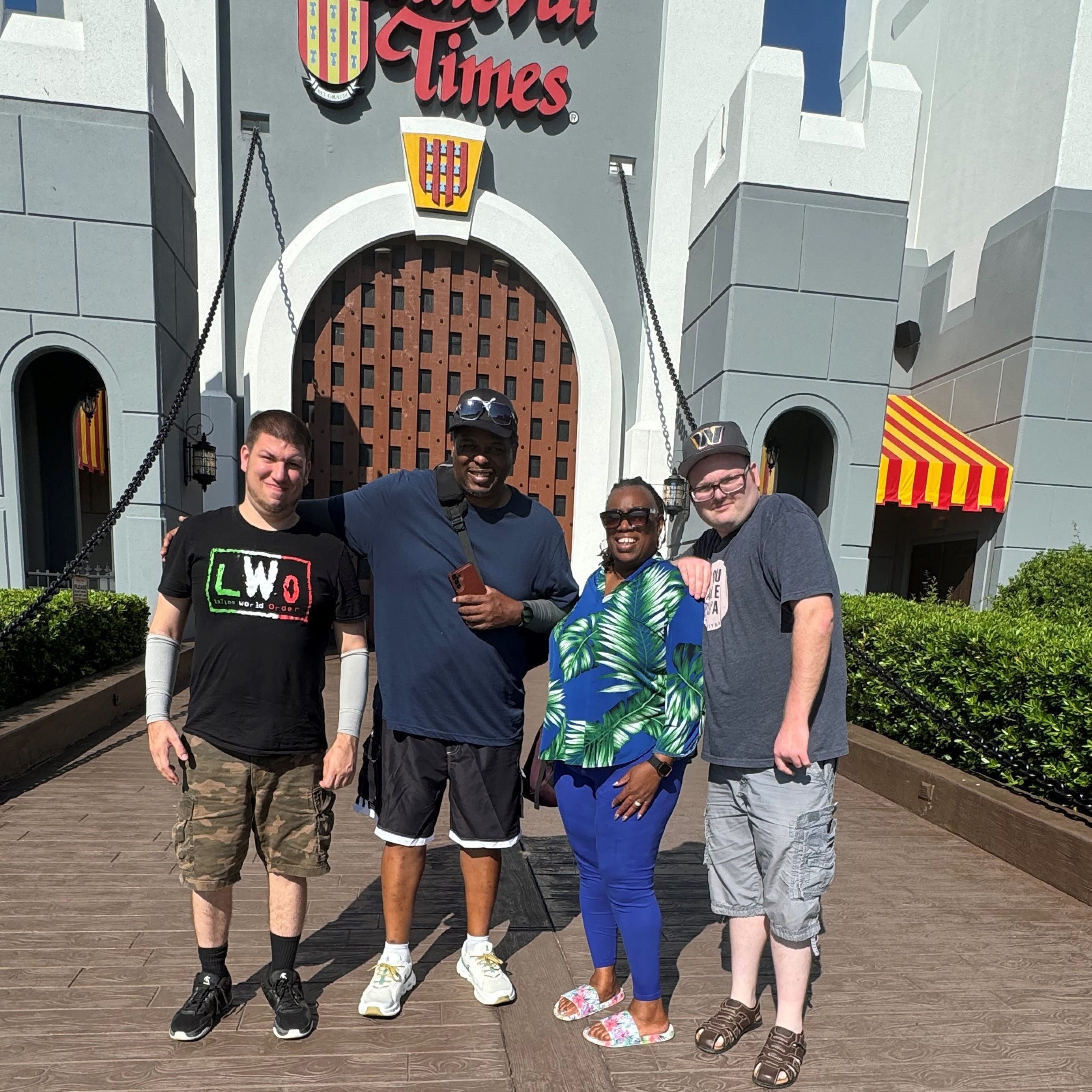 A group of people standing outside the Drawbridge of a Medieval Times Castle.