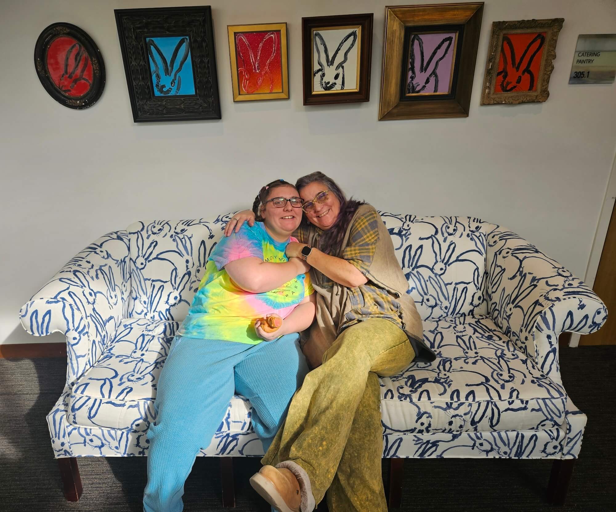 Two women sitting on a couch hugging